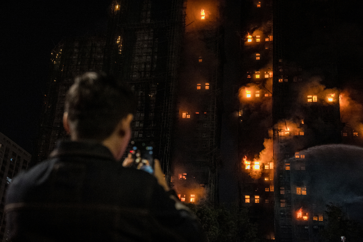 Una persona fotografía un incendio en un apartamento en Tai Po, Hong Kong, China, el 26 de noviembre de 2025. Según el gobierno de Hong Kong, el incendio de cinco alarmas, que comenzó el 26 de noviembre, ha dejado al menos 13 personas muertas y tres en estado crítico.