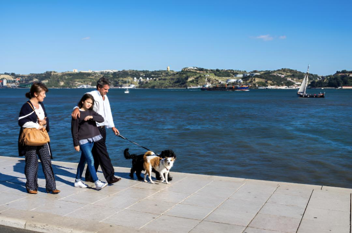 alt="alt="Una familia paseando a sus mascotas por el barrio de Belém, en Lisboa""