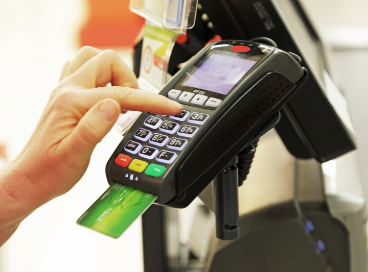 Persona ingresando su número PIN en una máquina de tarjetas