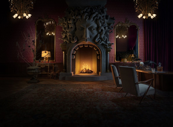 Chimenea gótica inspirada en Miércoles, con un rostro esculpido, lámparas victorianas y decoración de la Academia Nevermore.