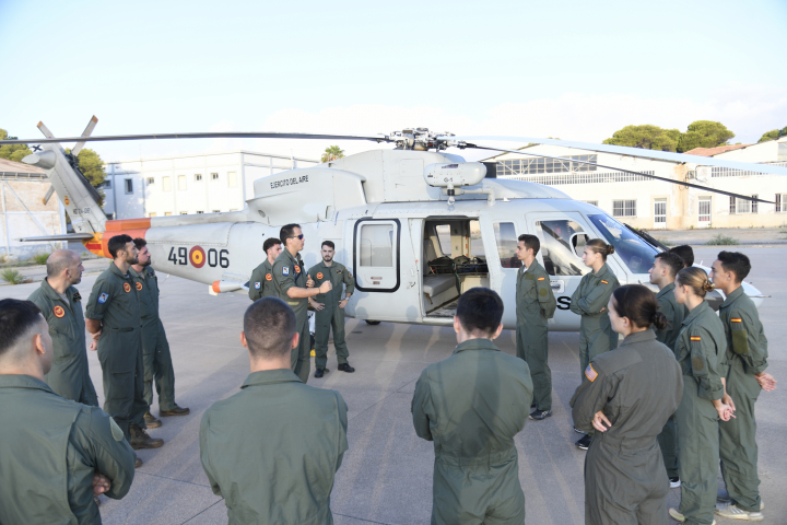 alt="alt="La princesa Leonor y sus compañeros de la Academia del Aire y del Espacio recibiendo instrucciones junto a un helicóptero""