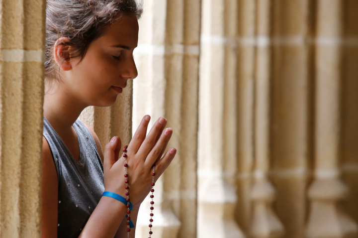 Una mujer reza en una iglesia