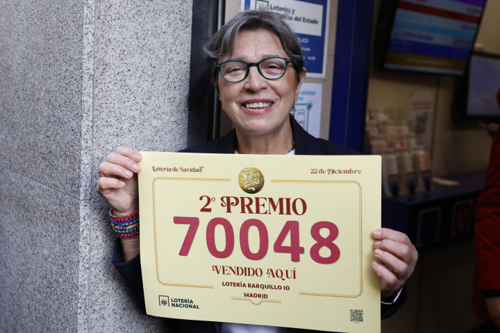 Raquel, una de las loteras de la administración de loterías del número 10 de la calle Barquillo, en Madrid, donde se ha vendido íntegramente el 70.048, el segundo premio del Sorteo Extraordinario de la Lotería de Navidad.
