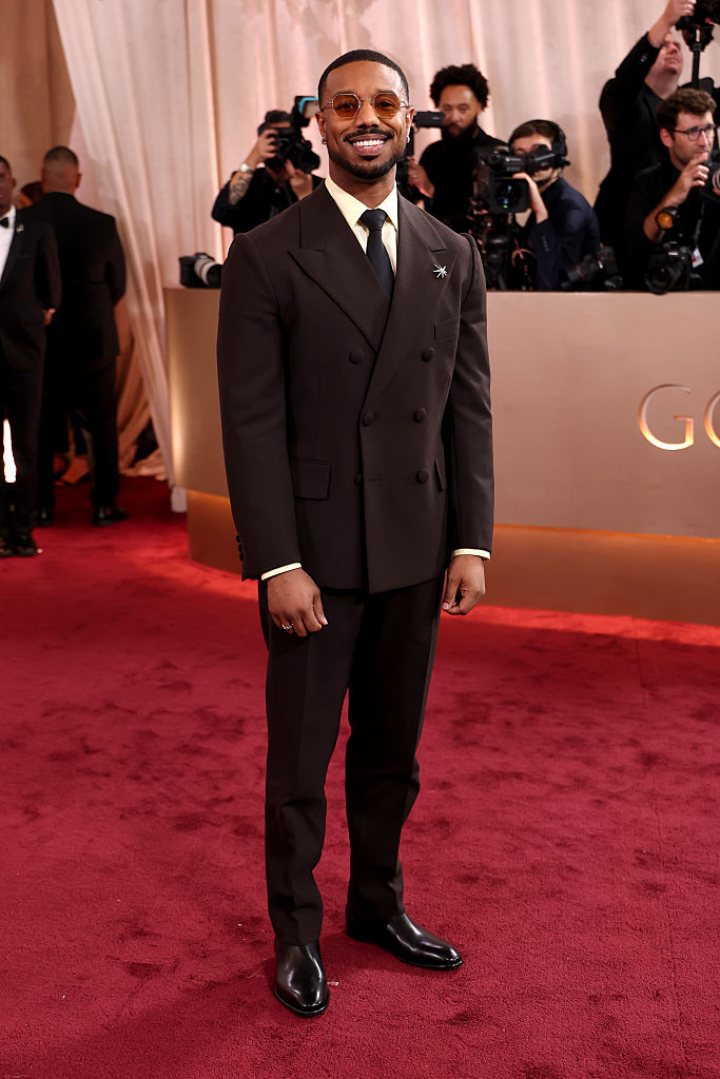 alt="alt="El protagonista de 'Los pecadores', con un traje marrón chocolate de americana cruzada y con otra de las tendencias de la alfombra roja: las gafas de sol.""