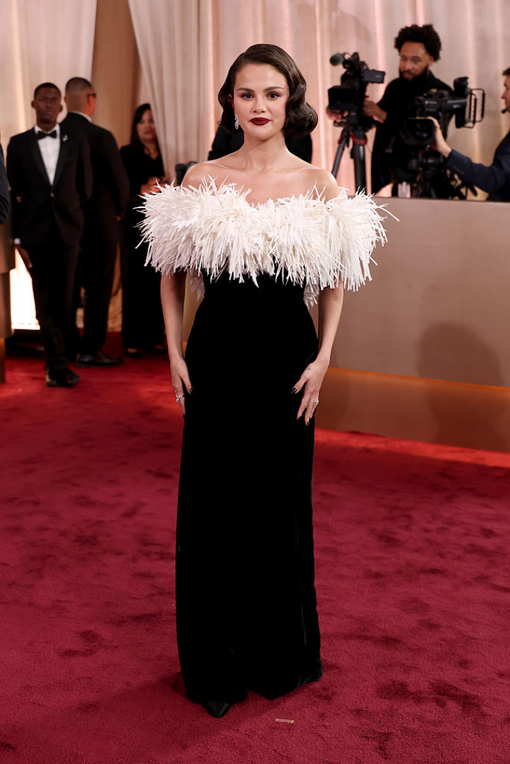 alt="alt="La actriz y cantante aportó por un diseño bicolor con un gran escote de plumas como protagonista. Además, Gómez se maquilló los labios en color vino, una de las tendencias de la temporada.""