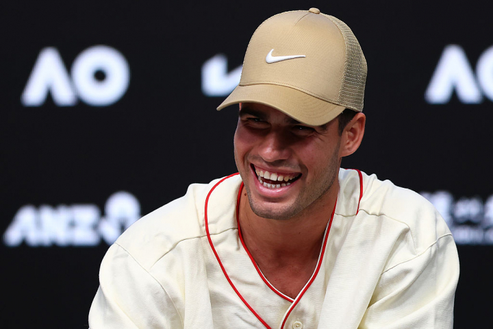 alt="alt="En su primera rueda de prensa del Open de Australia, Alcaraz eligió una camiseta de estilo beisbolera en tono beige con una gorra a juego.""