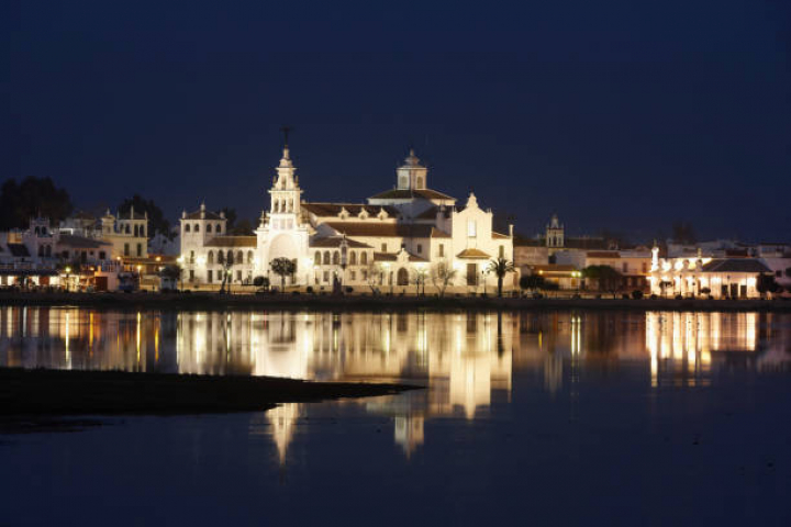 alt="alt="Spain, Andalusia, El Rocio, 11.02.2011, View on the village with the Ermita del Rocio in the night""