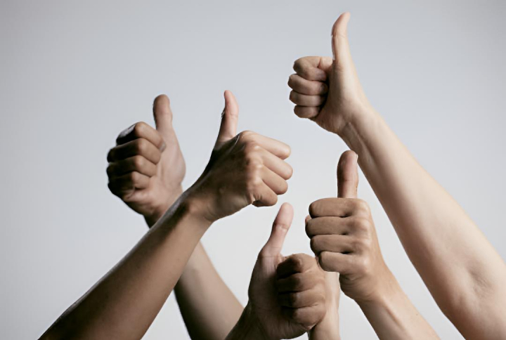 alt="alt="Varias personas con la mano en alto y el pulgar hacia arriba""