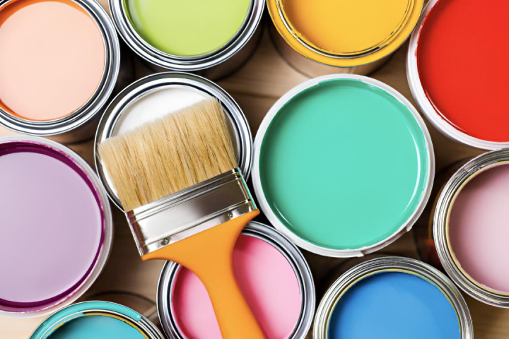 alt="alt="Varios botes de pintura de colores vibrantes y una brocha""