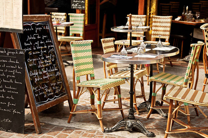 alt="alt=""Colorful tables and chairs in sidewalk cafeParis, France"""
