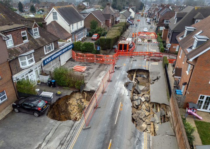 Una fotografía aérea muestra un socavón en la carretera el 19 de febrero de 2025 en Godstone, Inglaterra. El socavón apareció en Godstone High Street, Surrey, el lunes por la noche y alcanzó los 20 metros de longitud al mediodía siguiente.