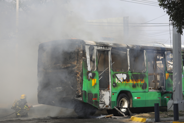 Un integrante del Cuerpo de Bomberos de Guadalajara intenta apagar un vehículo incendiado este domingo, en Guadalajara (México).