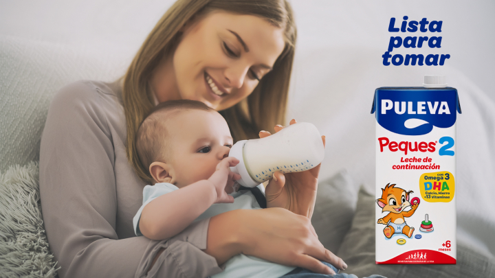 Una madre da el biberón a su hijo.