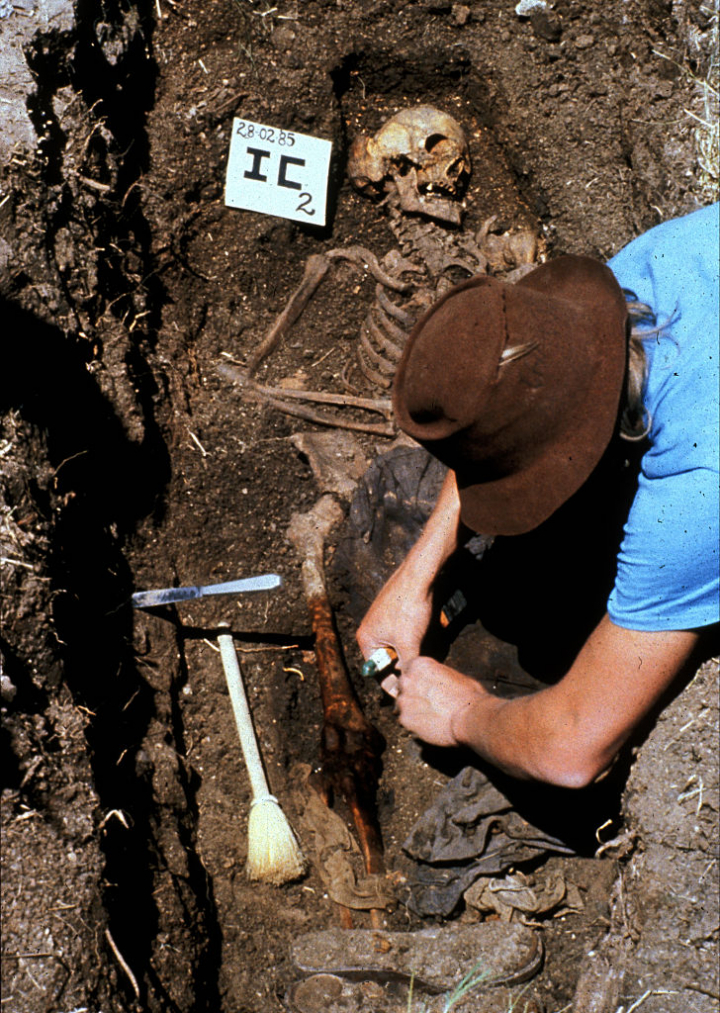 Un antropólogo trabaja en la exhumación del cuerpo de un represaliado por la dictadura argentina, en un cementerio sin identificar, en 1984.