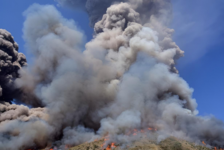 alt="alt="El humo se eleva y las llamas se propagan por la ladera tras la erupción del volcán Stromboli, al norte de Sicilia.""