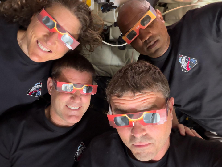 Los astronautas con las gafas para ver el eclipse solar.