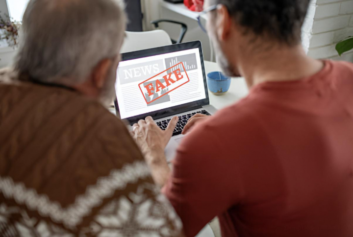 alt="alt="Dos personas mirando una página web falsa desde el ordenador""