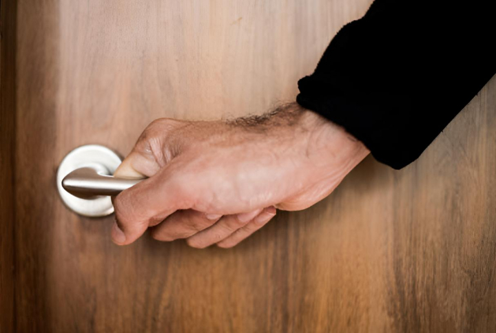 alt="alt="La mano de una persona en el pomo de una puerta""