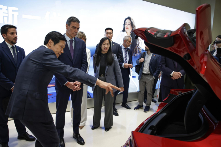 El CEO de Xiaomi, Lei Jun, explicándole a Sánchez cosas del coche SU7.