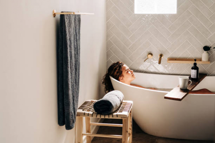 alt="alt="Young woman relaxing in bath tub. Self care and mental health concept.""