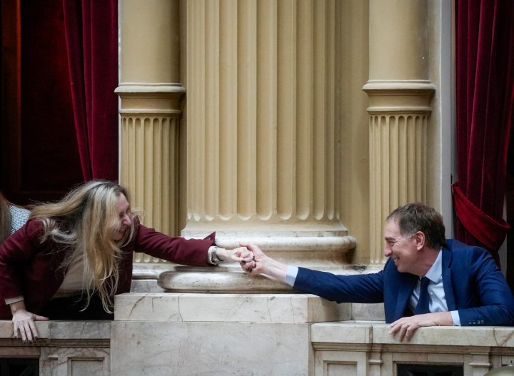 La Secretaria General de la Presidencia argentina, Karina Milei, intercambia un apretón de manos con el ministro de Interior, Diego Santili, en el Congreso.