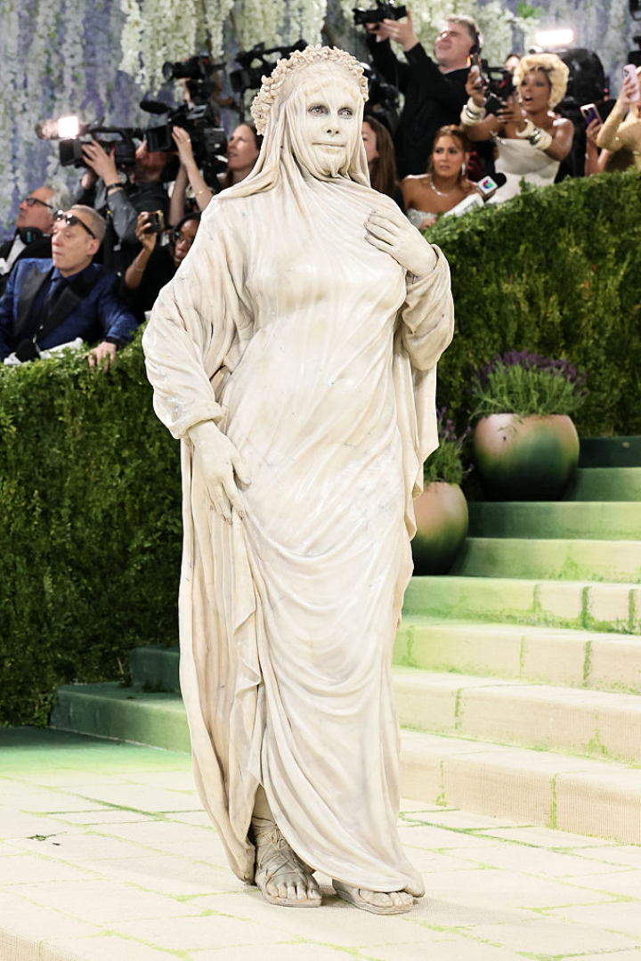 alt="alt="Irreconocible, la modelo ha pisado la alfombra roja emulando una estatua velada.""