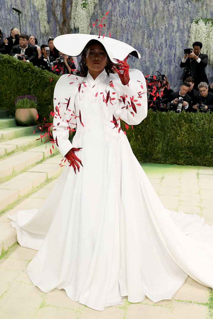 alt="alt="La tenista ha elegido un vestido en forma de abrigo de Robert Wun con plumas rojas y guantes a juego.""