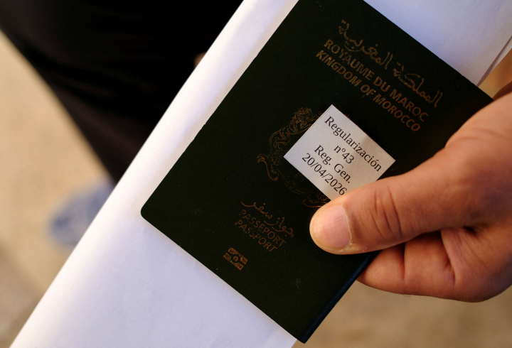 Una persona con su pasaporte y su ticket para los trámites de regularización en Almería.