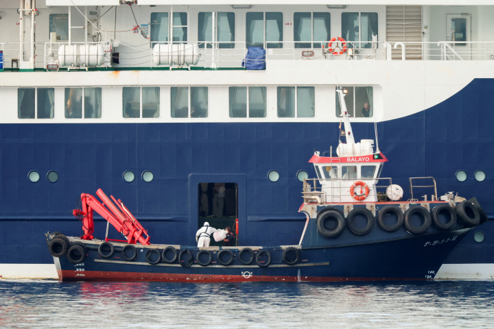 alt="alt="A person wearing personal protective equipment (PPE) on a boat transfers a package to the cruise ship MV Hondius at the port of Granadilla de Abona after being affected by a hantavirus outbreak in Tenerife, Spain, May 10, 2026. REUTERS/Hannah McKay  REFILE - CORRECTING INFORMATION FORM "RETRIEVES A PACKAGE FROM THE CRUISE SHIP" TO " TRANSFERS A PACKAGE TO THE CRUISE SHIP".""