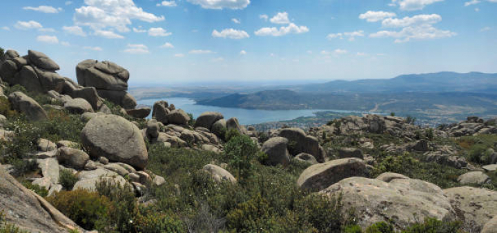 alt="alt="Large panorama view of Embalse de Manzanar el Real or de Santillana and the small town of Manzanar el Real, taken from La Pedriza, wilderness area near Madrid in the Guadarrama mountain range (Sierra de Guadarrama).""