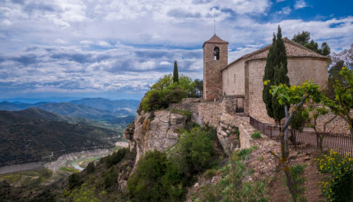 alt="alt="SIURANA, SPAIN - MAY 1: A general view of the Romanesque Church of Santa Maria with the almost empty river reservoir seen in the back on May 1, 2024 in Siurana, Spain. In the midst of a severe drought, Siurana remains one of the most attractive cities in Spain. The city was built on a limestone rock in the Priorat region of Catalonia and has a fortress from the Middle Ages. (Photo by Xurxo Lobato/Getty Images)""