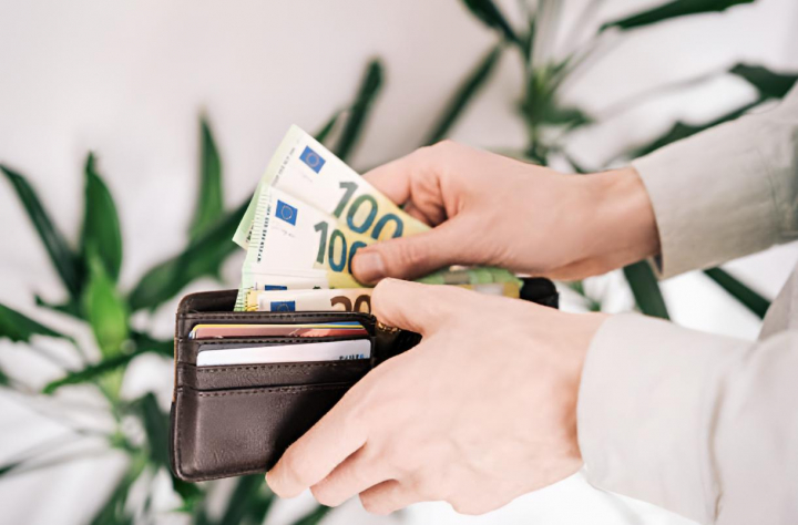 Un hombre sacando billetes de 100 euros de una cartera