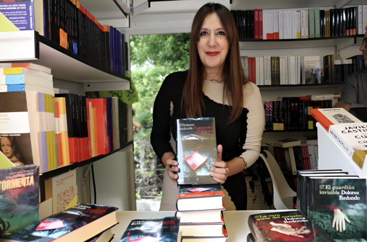 alt="alt="La escritora Dolores Redondo posando con su libro 'El guardián invisible'""
