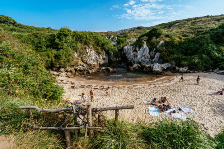 alt="alt="LLANES, ASTURIAS, SPAIN - 2019/08/24: People having sun in Gulpiyuri beach,  a flooded sinkhole with an inland beach. (Photo by Raquel Maria Carbonell Pagola/LightRocket via Getty Images)""
