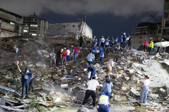 alt="alt="Integrantes de cuerpos de emergencia buscan víctimas este miércoles, luego de dos fuertes terremotos que sacudieron el Caribe venezolano""