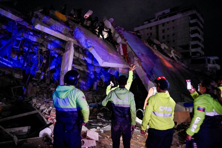 Personal de emergencia busca supervivientes entre las ruinas de un edificio derrumbado por el doble terremoto en La Guaira, Venezuela.
