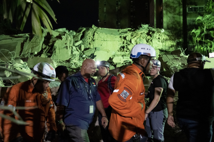 Trabajadores de emergencias trabajan entre los escombros de edificios en Caracas, Venezuela, tras el terremoto