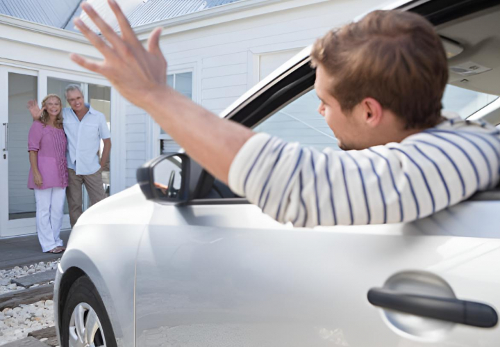 alt="alt="Un joven dice adiós desde el coche a sus padres""
