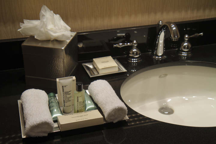 Botecitos de champú y gel en el baño de un hotel