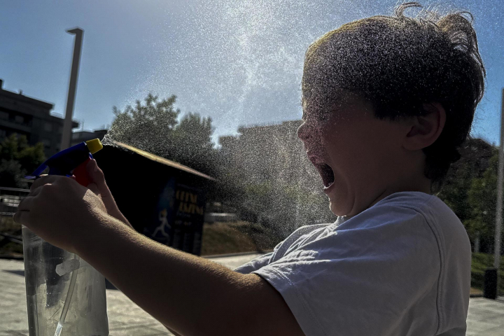Un niño refrescándose en un parque de Getxo durante la ola de calor de junio.