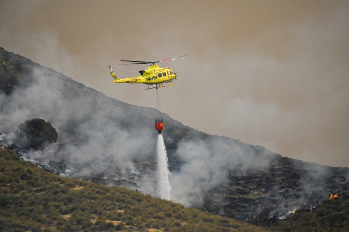alt="alt="Un helicóptero del servicio de extinción de incendios arroja agua sobre uno de los focos del incendio forestal declarado en Los Gallardos, Almería.""