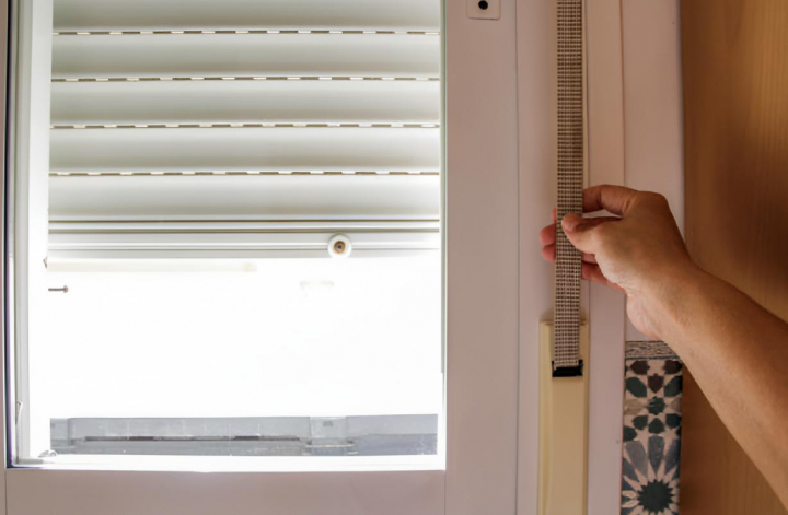 Una persona bajando la persiana de casa