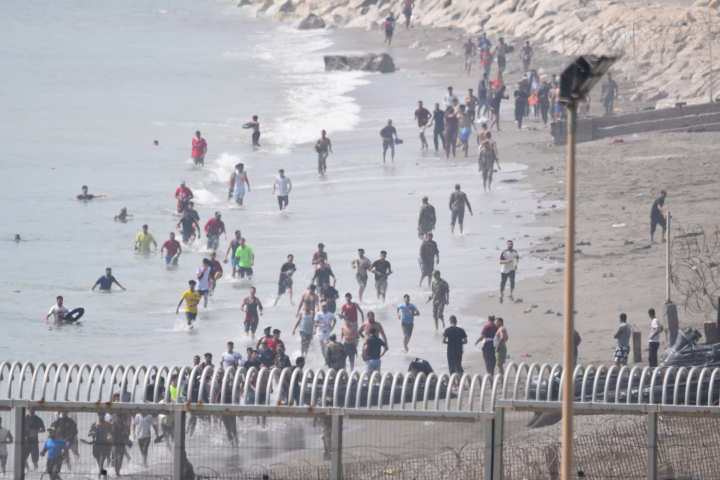Migrantes tratando de pasar la frontera en Ceuta, España.