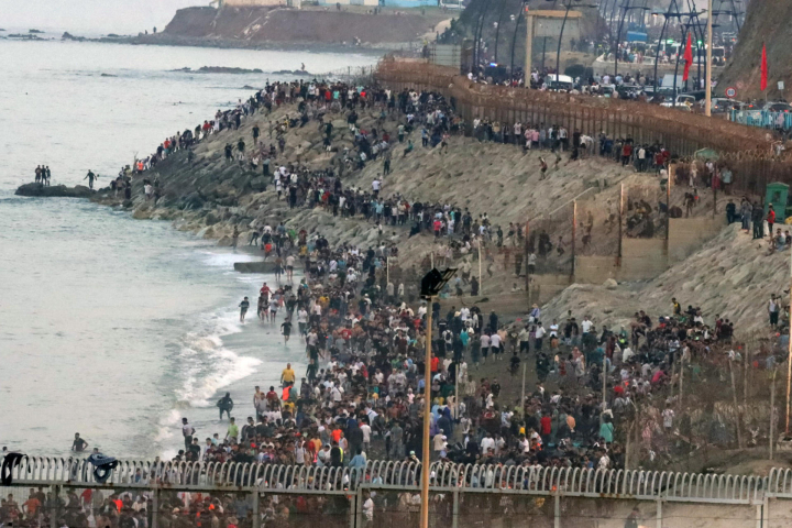 alt="alt="Decenas de personas esperan poder cruzar la frontera""