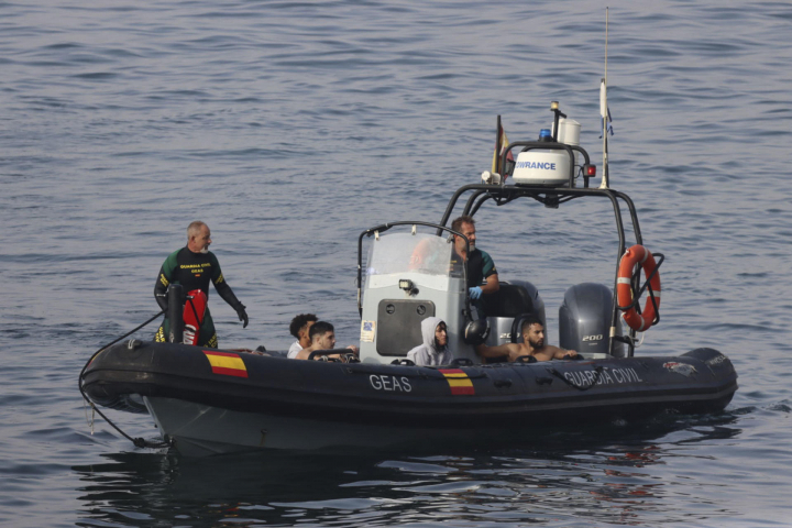 alt="alt="Miembros de la Guardia Civil socorren a algunos de los migrantes que se han lanzado al agua""
