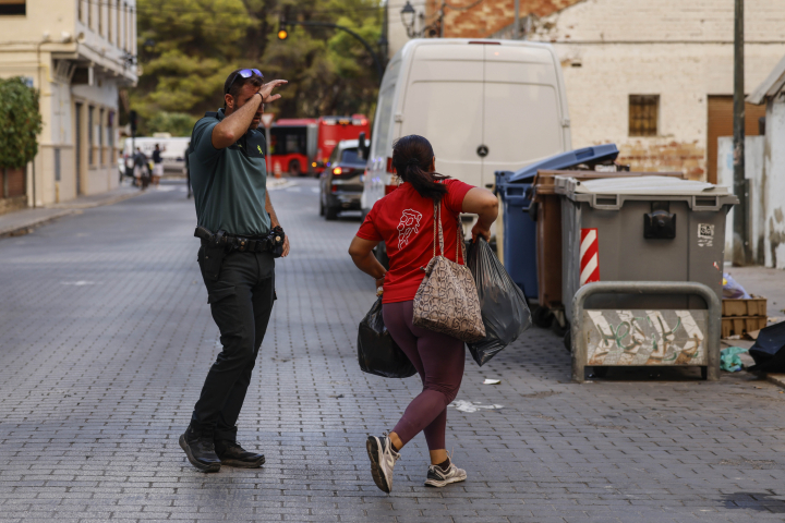 alt="alt="Una mujer es evacuada por las autoridades ante el avance del incendio""