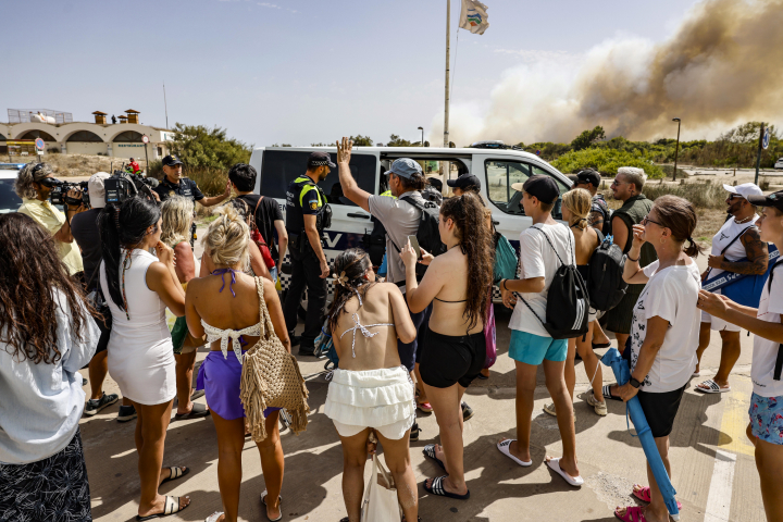 alt="alt="Varias personas están siendo evacuadas de la playa durante un incendio forestal el 27 de agosto de 2026 en Gola de Pujol, El Saler, Valencia, Comunidad Valenciana, España.""