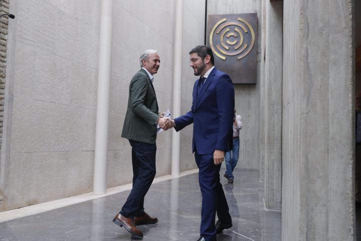 El candidato Vox al Gobierno de Aragón Alejandro Nolasco (d) estrecha la mano del candidato del PP a la Presidencia de Aragón Jorge Azcón .