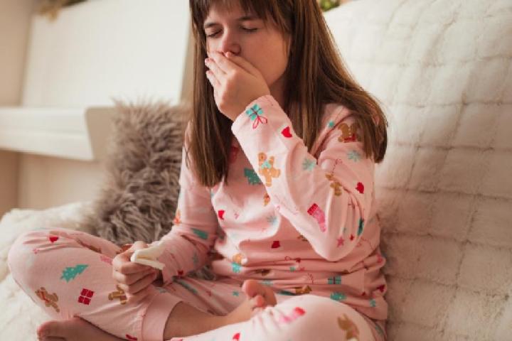 Una niña tosiendo