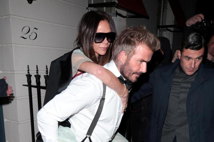 David Beckham, llevando a Victoria Beckham a caballito tras la celebración del 50º cumpleaños de ella en Londres.
